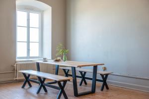 a table and bench in a room with a window at STF Visby Hamn Vandrarhem in Visby +32 photos