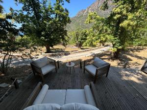 a wooden deck with two chairs and a table at Chalet studio in Porto Ota