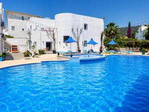 a large pool with blue water in front of a building at Bodrum Blu Hotel in Bodrum City