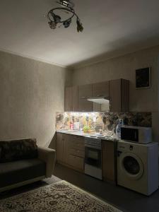 a kitchen with a microwave and a stove top oven at Piitota in Almaty
