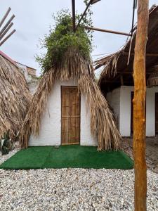 a small house with a door and a grass roof at Mar y Montana in Taganga