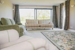 a living room with two couches and a large window at Ceunant in Llanfair Caereinion