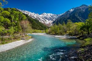 a view of a river with mountains in the background at Tabist Kazeyuki in Takayama
