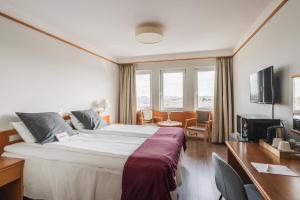 ein Hotelzimmer mit einem großen Bett und einem Fernseher in der Unterkunft 2Home Stockholm South in Stockholm