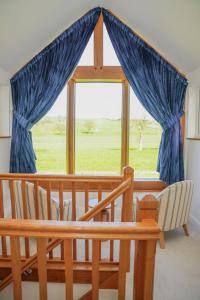 a large window with blue curtains in a room at Ceunant in Llanfair Caereinion