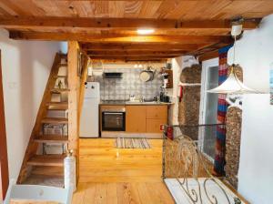 a small kitchen with a staircase in a tiny house at Interbeira Sandomil River Cottage in Seia +35 photos