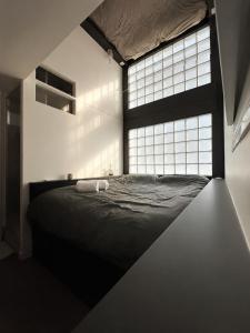 a bedroom with a black bed with a large window at Le miroir secret in Anglet
