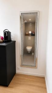 a mirror on a wall with a toilet in a room at Le miroir secret in Anglet