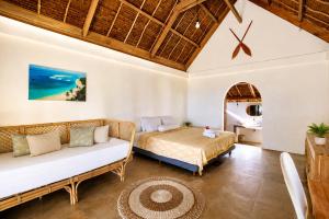 a bedroom with a bed and a couch at Jala Villas Lances Right HTs Mentawai in Katiet