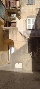 an old building with a window and a stair case at Calvi centre ville in Calvi