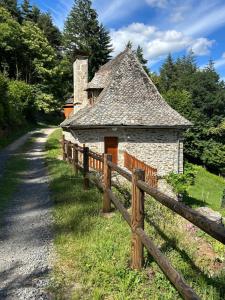 an old stone building next to a wooden fence at L'Oustalou de Petit Jean in Cassaniouze