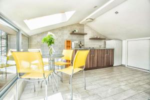 a kitchen and dining room with yellow chairs and a table at Apartment SM in Herceg-Novi +40 photos