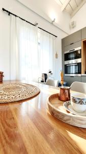 ein Wohnzimmer mit Holzboden und einem Tisch in der Unterkunft Pelekas loft in Pelekas