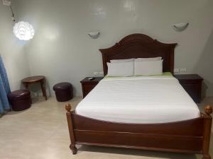 a bedroom with a large bed with white sheets at B&S Pension House in Dipolog