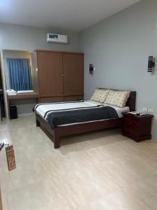 a bedroom with a bed with a wooden headboard at B&S Pension House in Dipolog