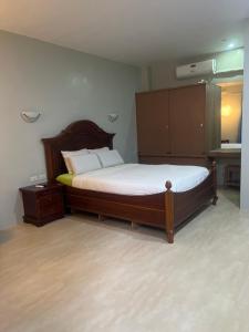 a bedroom with a large bed with a wooden headboard at B&S Pension House in Dipolog