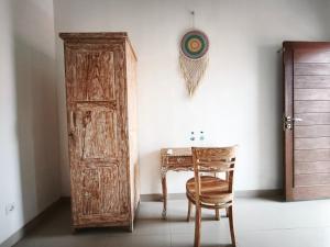 a room with a wooden door and a table and a chair at Sun Homestay Canggu in Canggu