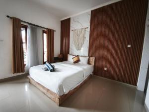 a bedroom with a bed with a laptop on it at Sun Homestay Canggu in Canggu +10 photos