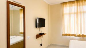 a room with a tv and a bed and a mirror at Udaigarh Palace - The Heritage Hotel in Jodhpur