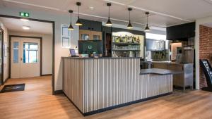 a kitchen with a bar with a counter top at Campanile NATURE - Brive-la-Gaillarde in Brive-la-Gaillarde +62 photos