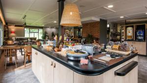 a bakery with a buffet of food on a counter at Campanile NATURE - Brive-la-Gaillarde in Brive-la-Gaillarde