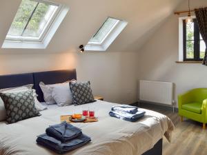 a bedroom with a bed with a tray of food on it at Jupiter Barn in Swafield
