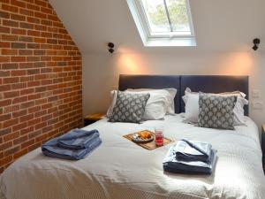 a bed with towels and a tray of food on it at Jupiter Barn in Swafield +13 photos