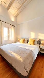 ein großes weißes Bett in einem Zimmer mit Fenster in der Unterkunft Pelekas loft in Pelekas