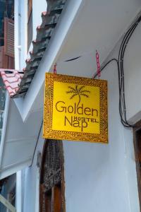 a yellow sign hanging on the side of a building at Golden Nap hostel in Zanzibar City