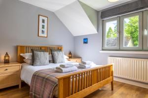 a bedroom with a bed with towels on it at Loch Ness Abbey Cottages in Fort Augustus +60 photos