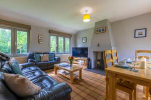 a living room with a couch and a table at Loch Ness Abbey Cottages in Fort Augustus