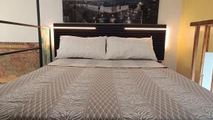 a bed with a gray comforter and two pillows at lovely vintage apartment climatizzato inalpi in Turin