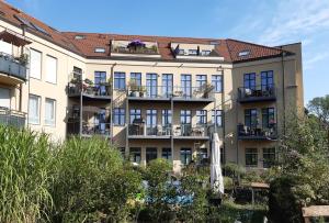an apartment building with balconies and plants at Am Schlosspark Potsdam in Potsdam