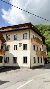 a large white building with windows on a street at Hotel Lucija in Most na Soči