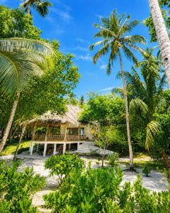 a house on the beach with palm trees at Jala Villas Lances Right HTs Mentawai in Katiet