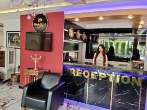 a woman standing at a bar in a restaurant at Max Nova Hotel in Alanya +53 photos