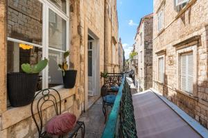 an alley with chairs and plants on a balcony at Villa Ofellia in Dubrovnik
