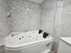 a white bath tub in a bathroom with marble walls at la herencia B VUT 1693 in Ponferrada