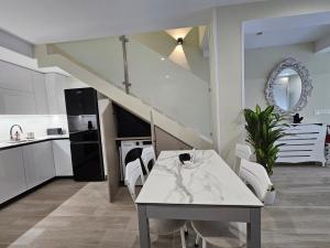 a kitchen with a white table and white chairs at la herencia B VUT 1693 in Ponferrada