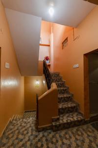 eine Treppe in einem Raum mit orangefarbenen Wänden und einer Decke in der Unterkunft Hotel Bisman in Jabalpur