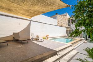 a patio with a pool and two dogs sitting next to a building at Ideal Property Mallorca - Can Peret in Sa Pobla