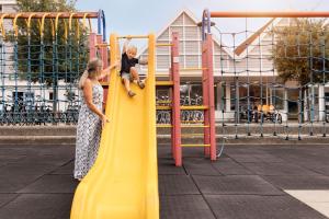 a woman and a child on a slide at a playground at Summio Parc Aquadelta in Bruinisse +25 photos