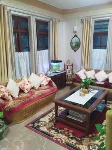 a living room with two couches and a fish tank at Laligurash in Mirik