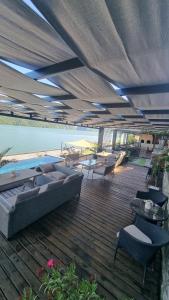 a patio with couches and tables and a pool at Casa Aless Eselnita Adults Only 14 plus in Eşelniţa