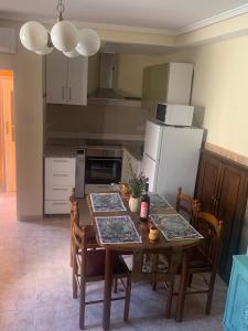 a kitchen with a table with chairs and a refrigerator at O recuncho - Alojamiento tranquilo cerca de Ribeira Sacra y Ourense in Maceda