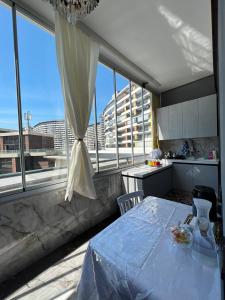 a kitchen with a table and a large window at Green Ville Residence in Baku