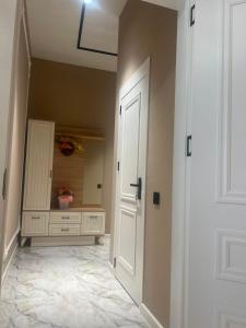 a hallway with a white door and a vase of flowers at Green Ville Residence in Baku +32 photos