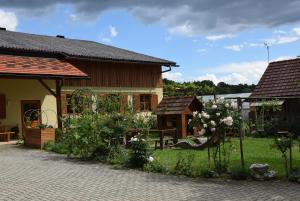 a house with a garden with a bench and flowers at Bauernhof Flucher-Plaschg in Straden