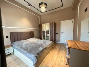 a bedroom with a bed and a wooden floor at Green Ville Residence in Baku