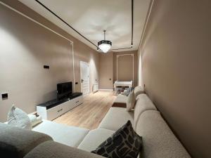 a living room with a couch and a television at Green Ville Residence in Baku